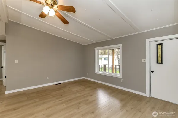 an empty room with wooden floor and windows