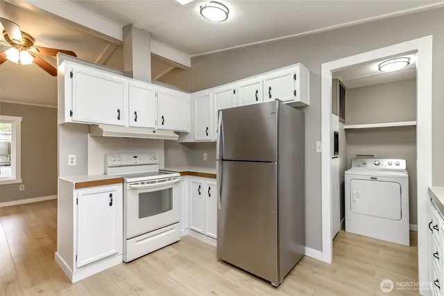 a kitchen with a refrigerator sink and cabinets
