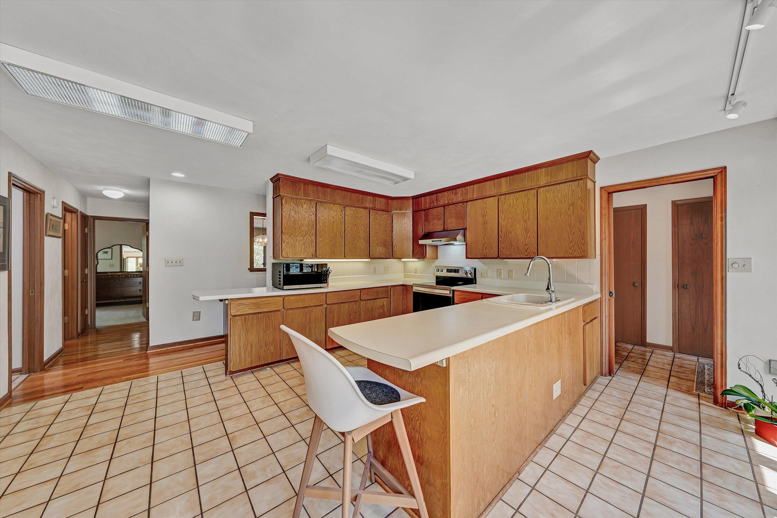 1124 Old Hollow Road Buchanan, VA 24066 - Photo 21 of 73 a large white kitchen with a stove a sink dishwasher and a refrigerator with wooden floor