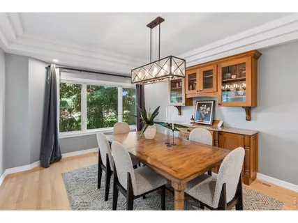 a dining room with furniture a floor to ceiling window and wooden floor