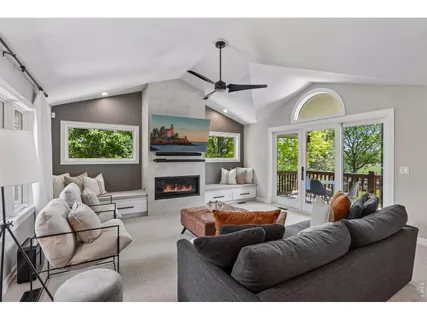 a living room with furniture a fireplace and a large window