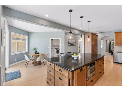 a kitchen with stainless steel appliances granite countertop a sink counter space and living room view