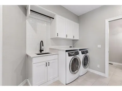 a utility room with sink dryer and washer