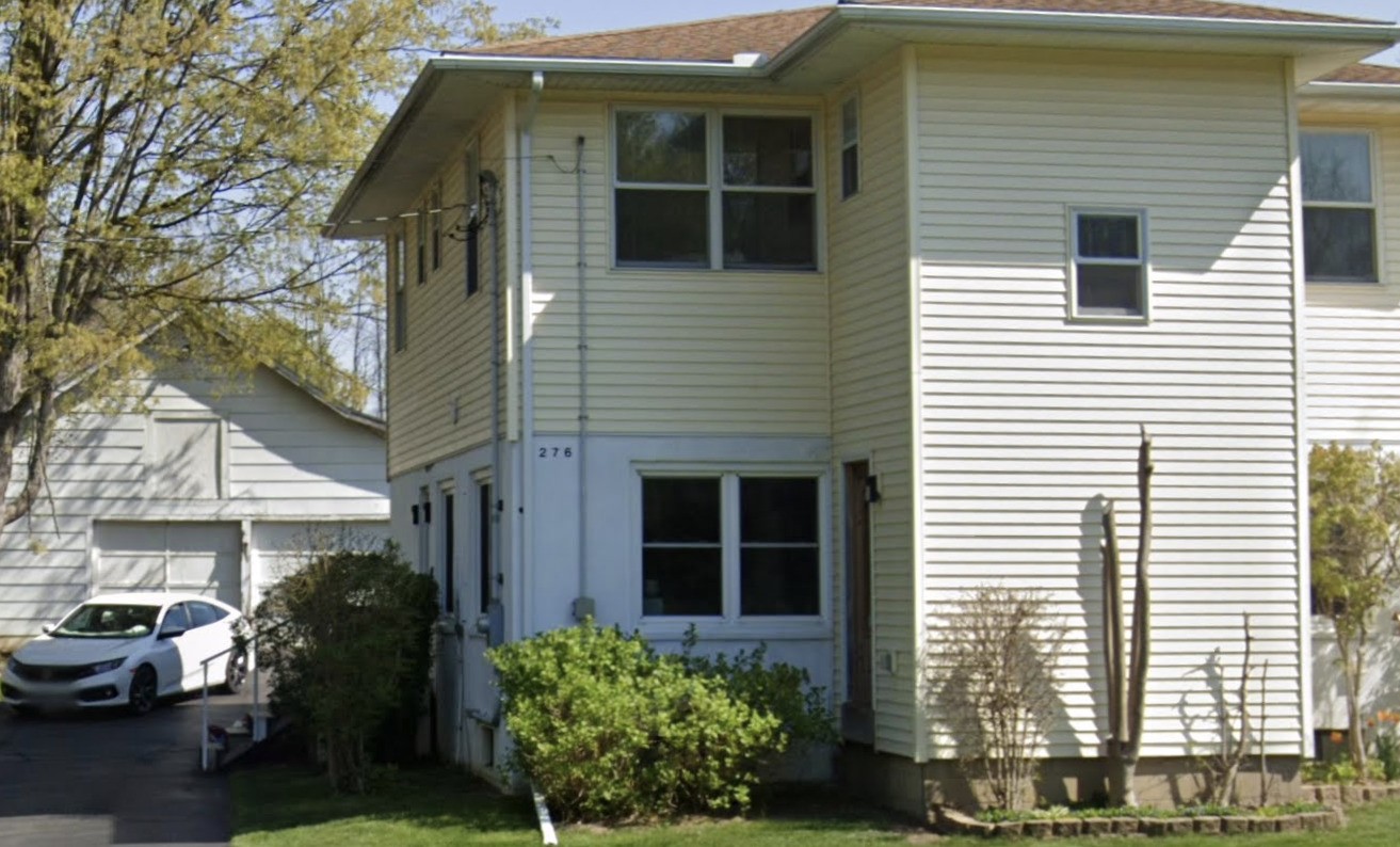 a view of a house with a yard and sitting area