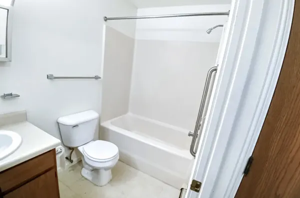 a white toilet sitting next to a bath tub