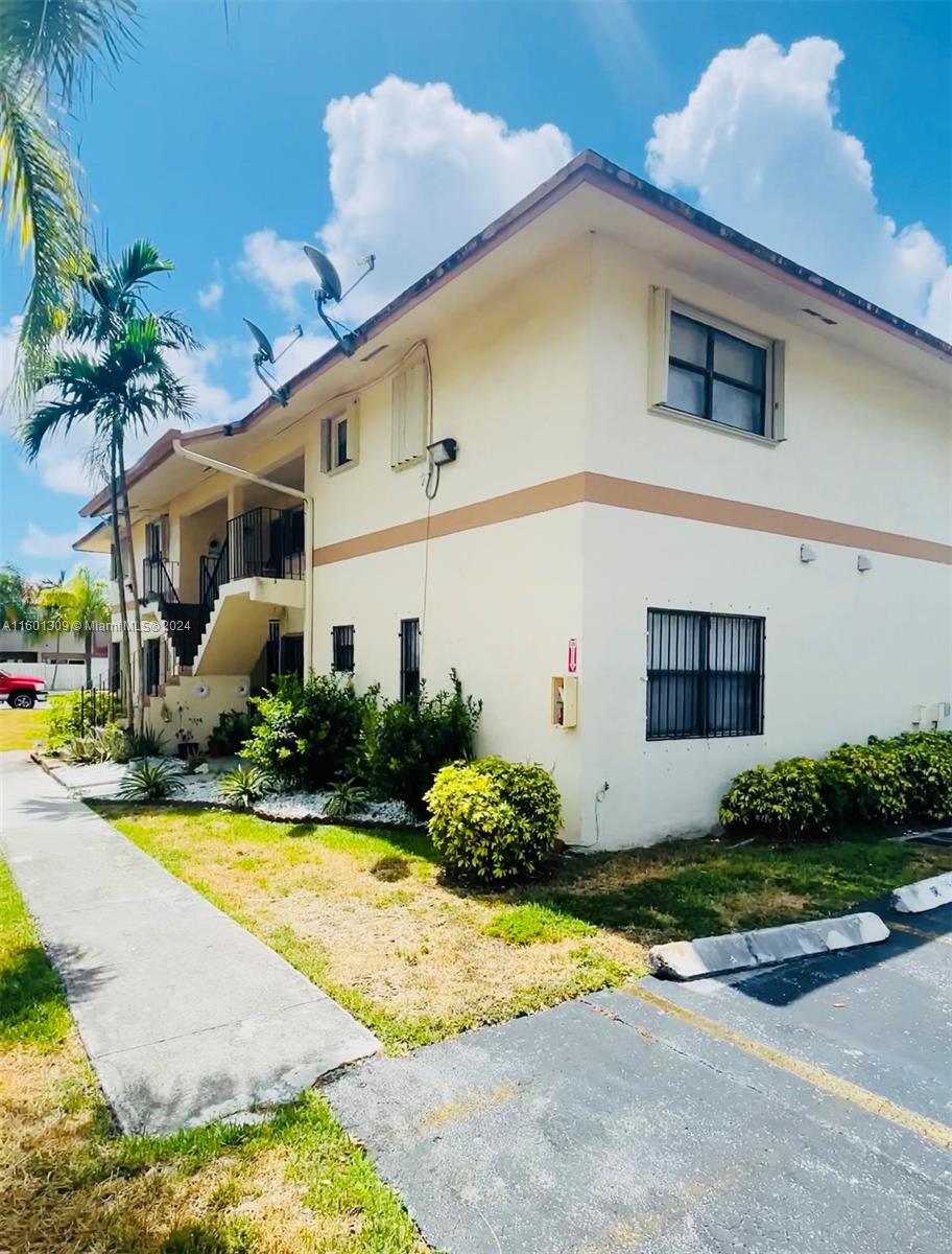6475 Southwest 129th Place, Unit 4034 Miami, FL 33183 - Photo 2 of 15 a front view of a house with a yard and garage