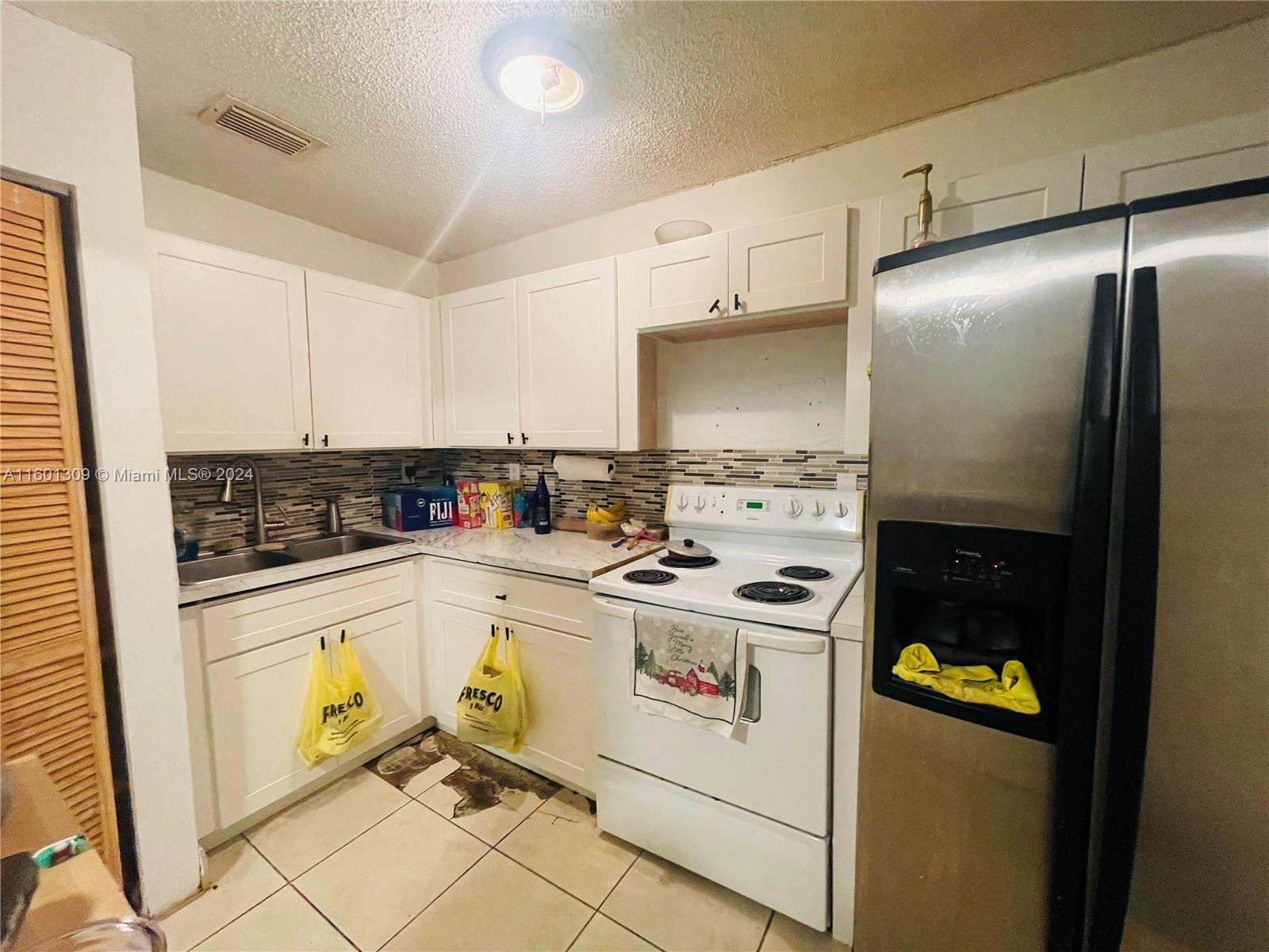 6475 Southwest 129th Place, Unit 4034 Miami, FL 33183 - Photo 6 of 15 a kitchen with a refrigerator and a stove top oven