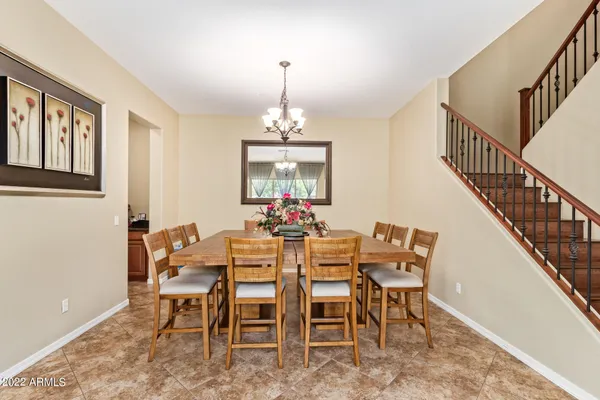a dining room with furniture a chandelier and wooden floor