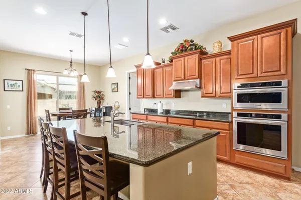 a kitchen with granite countertop a sink appliances and cabinets