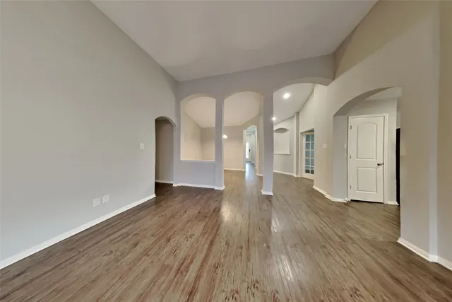 a view of empty room with wooden floor