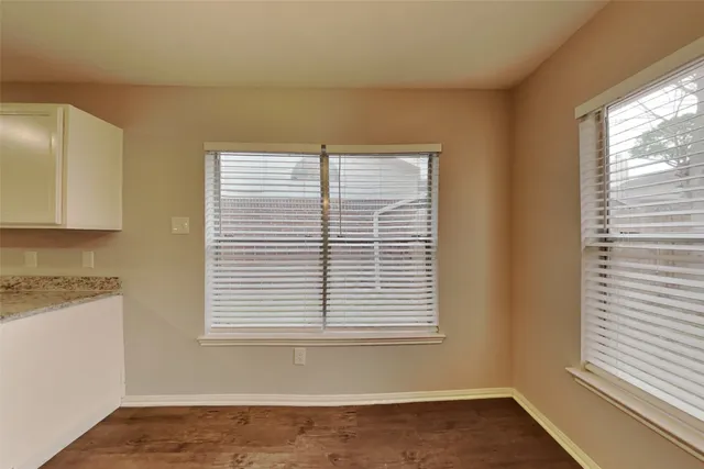 a view of a kitchen with wooden floor and a window