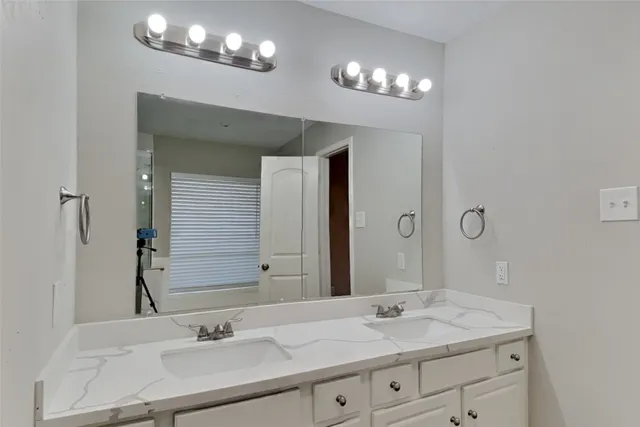 a bathroom with a sink double vanity and a mirror