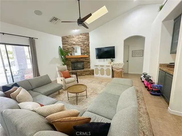 a living room with furniture a flat screen tv and a large window