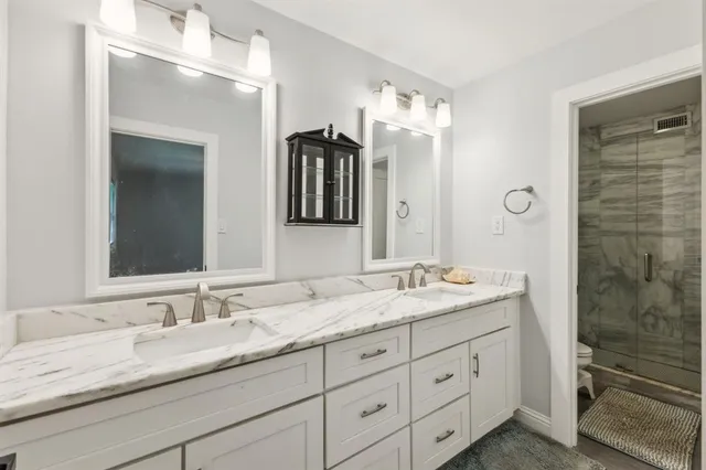 a bathroom with double sink and a mirror