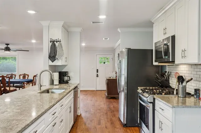 a kitchen with stainless steel appliances granite countertop a sink stove and refrigerator