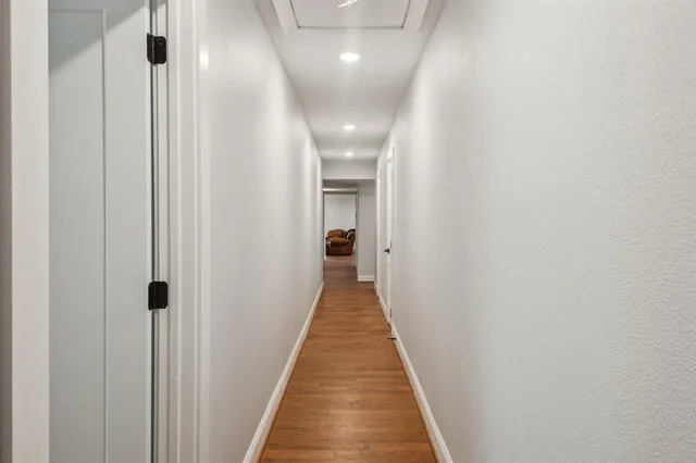 a view of a hallway with wooden floor