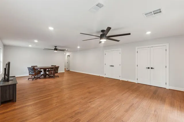 a view of a room with wooden floor and a ceiling fan
