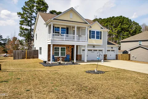 a front view of a house with a yard and seating space