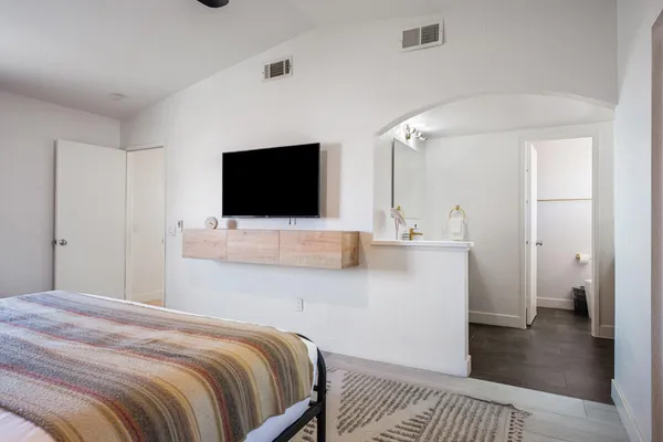 a bedroom with a bed and a flat screen tv