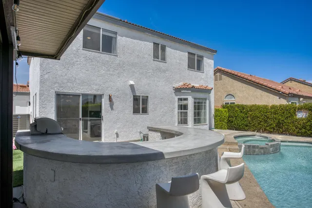 a view of a house with a table and chairs in patio