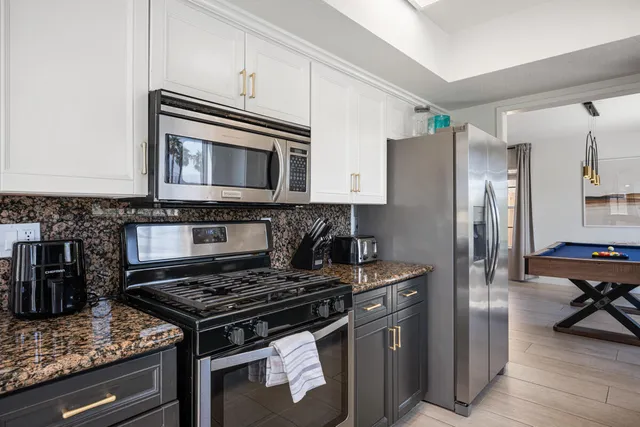 a kitchen with stainless steel appliances granite countertop a stove microwave and refrigerator