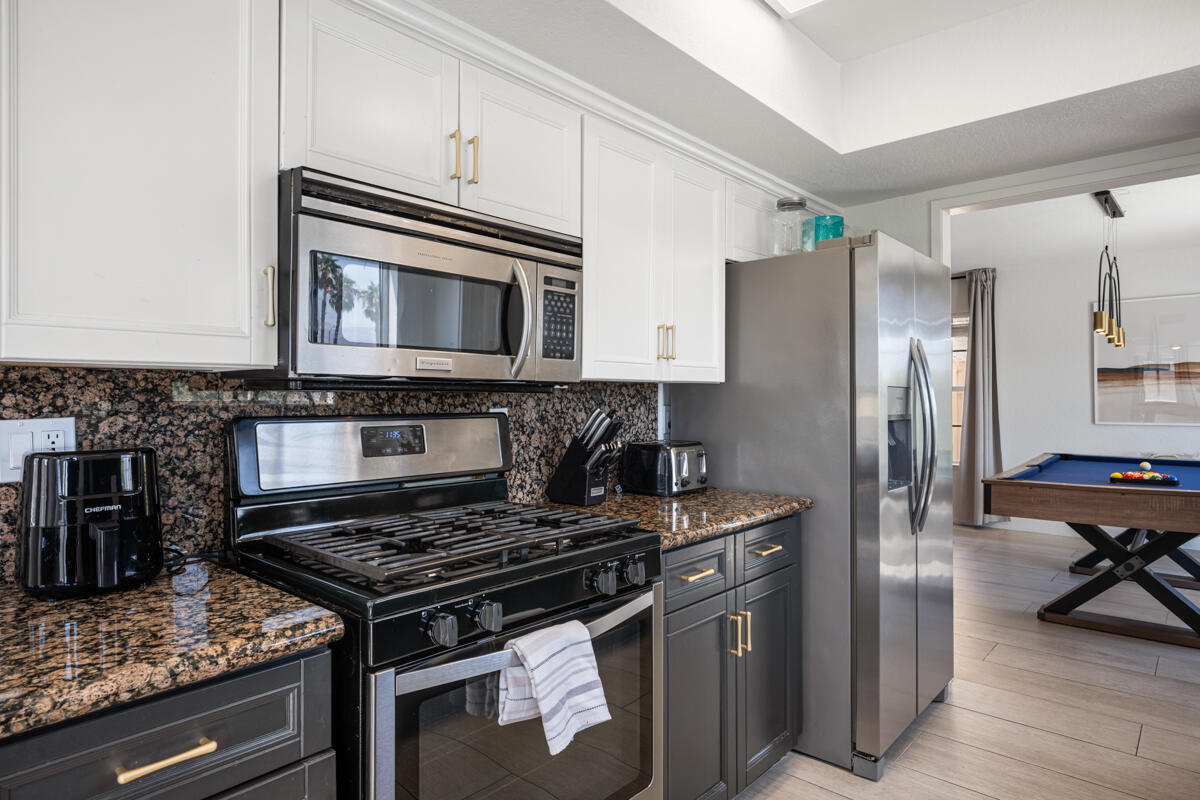 45640 Cimarron Road Indio, CA 92201 - Photo 9 of 28 a kitchen with stainless steel appliances granite countertop a stove microwave and refrigerator