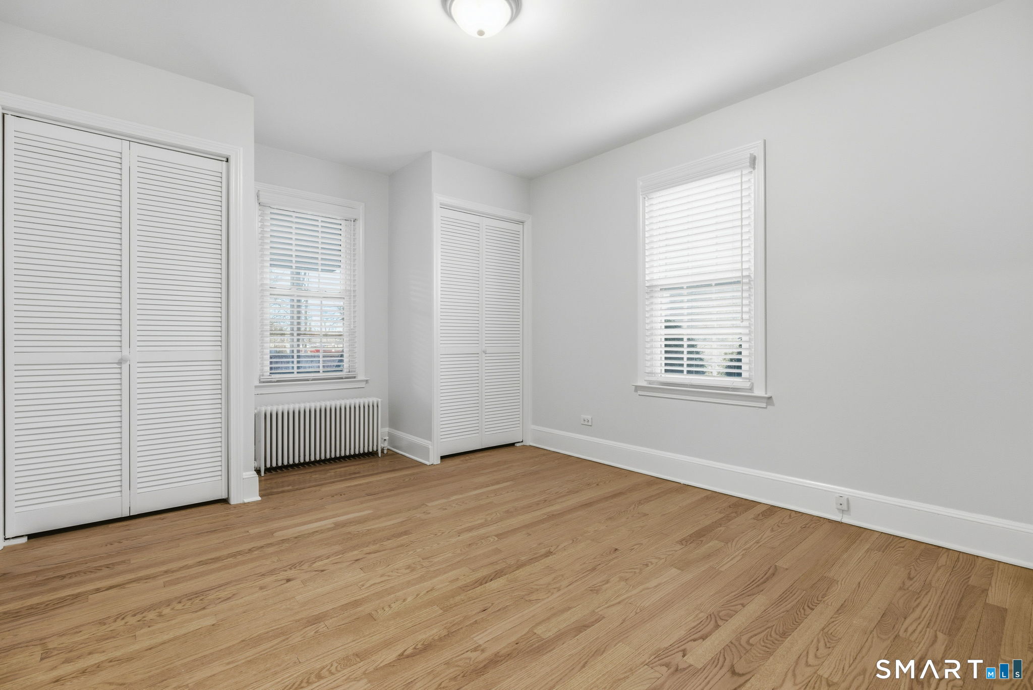 5 Bridge Street Norwalk, CT 06855 - Photo 6 of 11 an empty room with wooden floor and windows