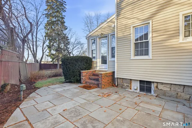 a backyard of a house with barbeque and wooden fence
