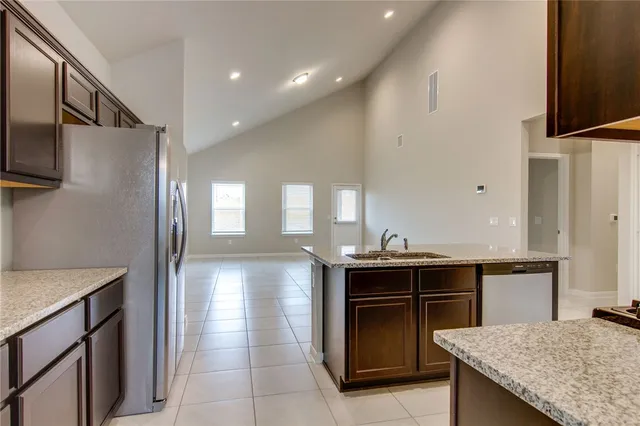 a kitchen with kitchen island a sink stove and refrigerator