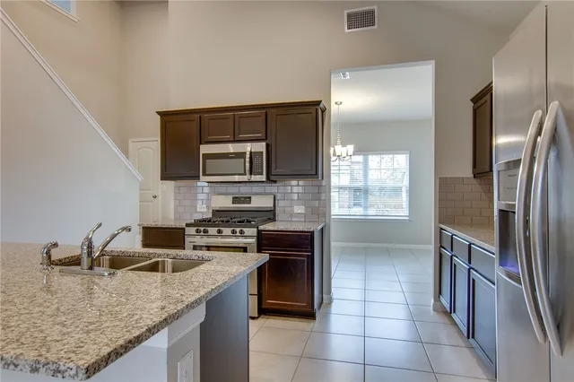 a kitchen with stainless steel appliances granite countertop a sink stove and refrigerator