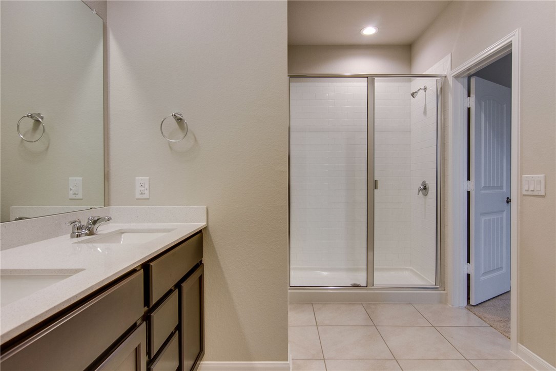 6916 Ranchito Drive Austin, TX 78744 - Photo 22 of 37 a bathroom with a shower sink and mirror