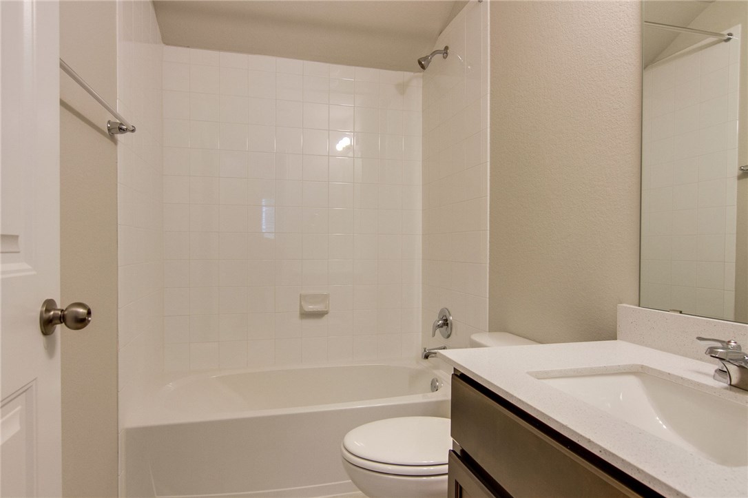 6916 Ranchito Drive Austin, TX 78744 - Photo 28 of 37 a bathroom with a granite countertop sink toilet and shower