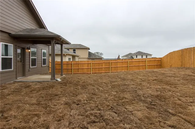 a view of backyard with wooden fence