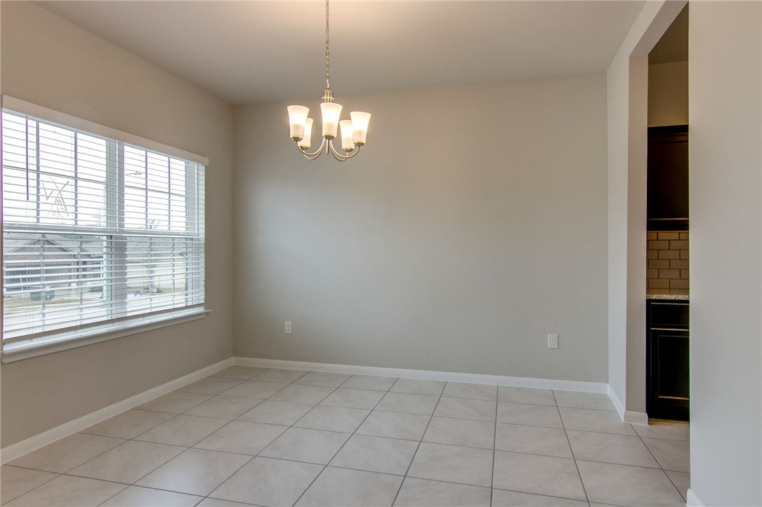 6916 Ranchito Drive Austin, TX 78744 - Photo 6 of 37 an empty room with chandelier fan and windows