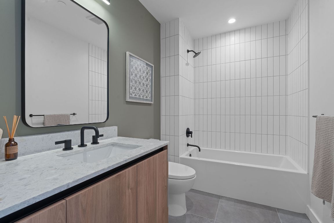 84 East Avenue, Unit 2410 Austin, TX 78701 - Photo 19 of 40 Representative of Property. Full bathroom featuring shower / tub combination, vanity, and light tile patterned flooring