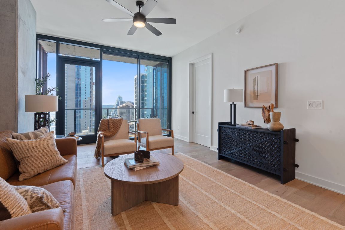 84 East Avenue, Unit 2410 Austin, TX 78701 - Photo 4 of 40 Representative of Property. Living room with expansive windows, light wood-style flooring, a view of city, and ceiling fan