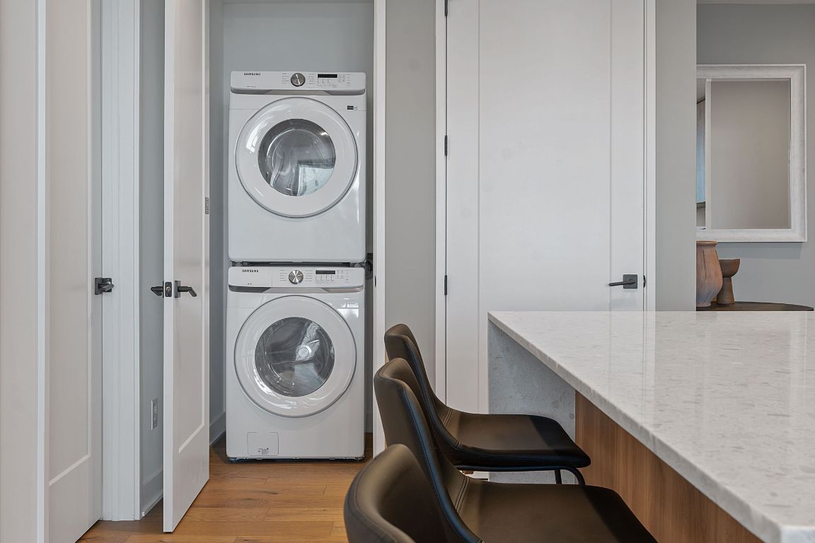 84 East Avenue, Unit 2410 Austin, TX 78701 - Photo 10 of 40 Representative of Property. Laundry area with light wood-style floors and stacked washer / drying machine