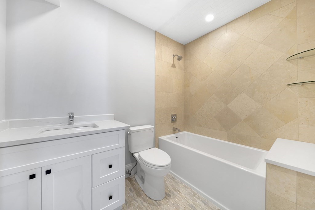 9 Whitford Street, Unit 9 Boston, MA 02131 - Photo 12 of 25 a bathroom with a granite countertop sink toilet a mirror and bathtub