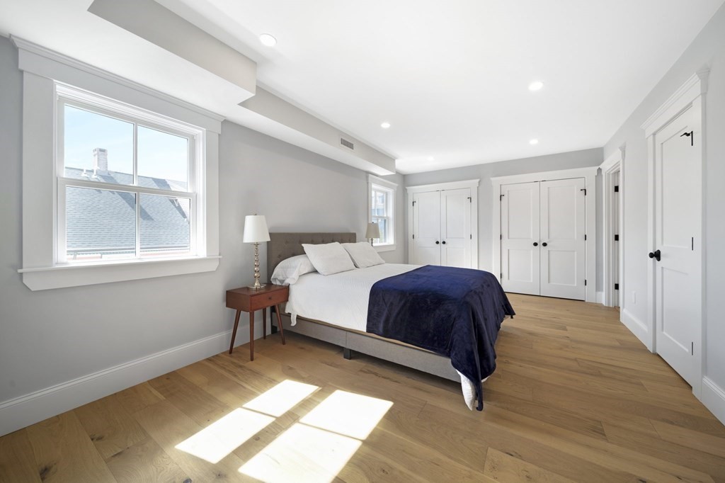 9 Whitford Street, Unit 9 Boston, MA 02131 - Photo 13 of 25 a spacious bedroom with a bed and wooden floor