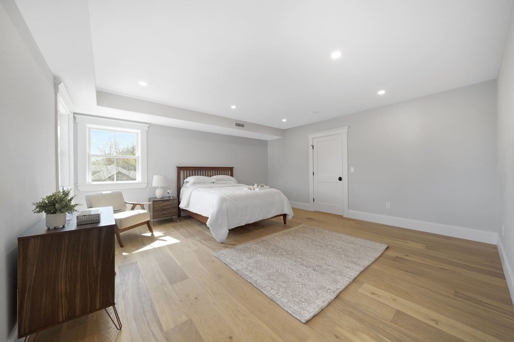 9 Whitford Street, Unit 9 Boston, MA 02131 - Photo 19 of 25 a spacious bedroom with a bed and a couch
