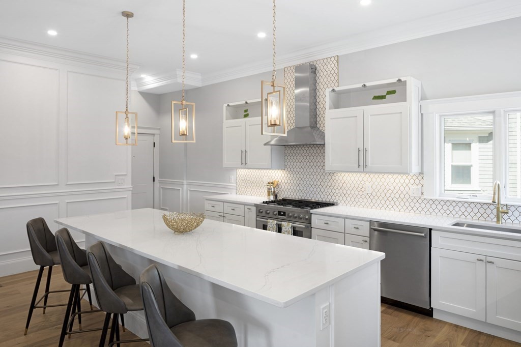 9 Whitford Street, Unit 9 Boston, MA 02131 - Photo 4 of 25 a kitchen with a table chairs stove and cabinets