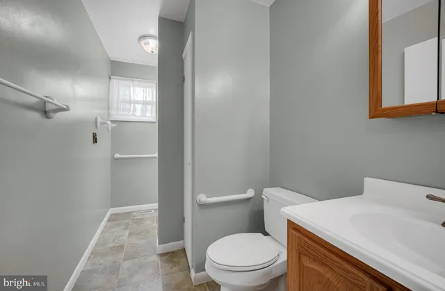 a white toilet sitting next to a bathroom sink and vanity