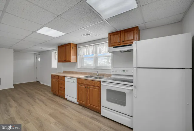 a kitchen with stainless steel appliances granite countertop a refrigerator a stove a sink dishwasher and wooden floor