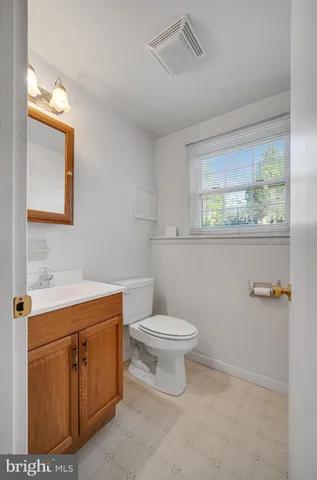 a bathroom with a toilet a sink a vanity and mirror