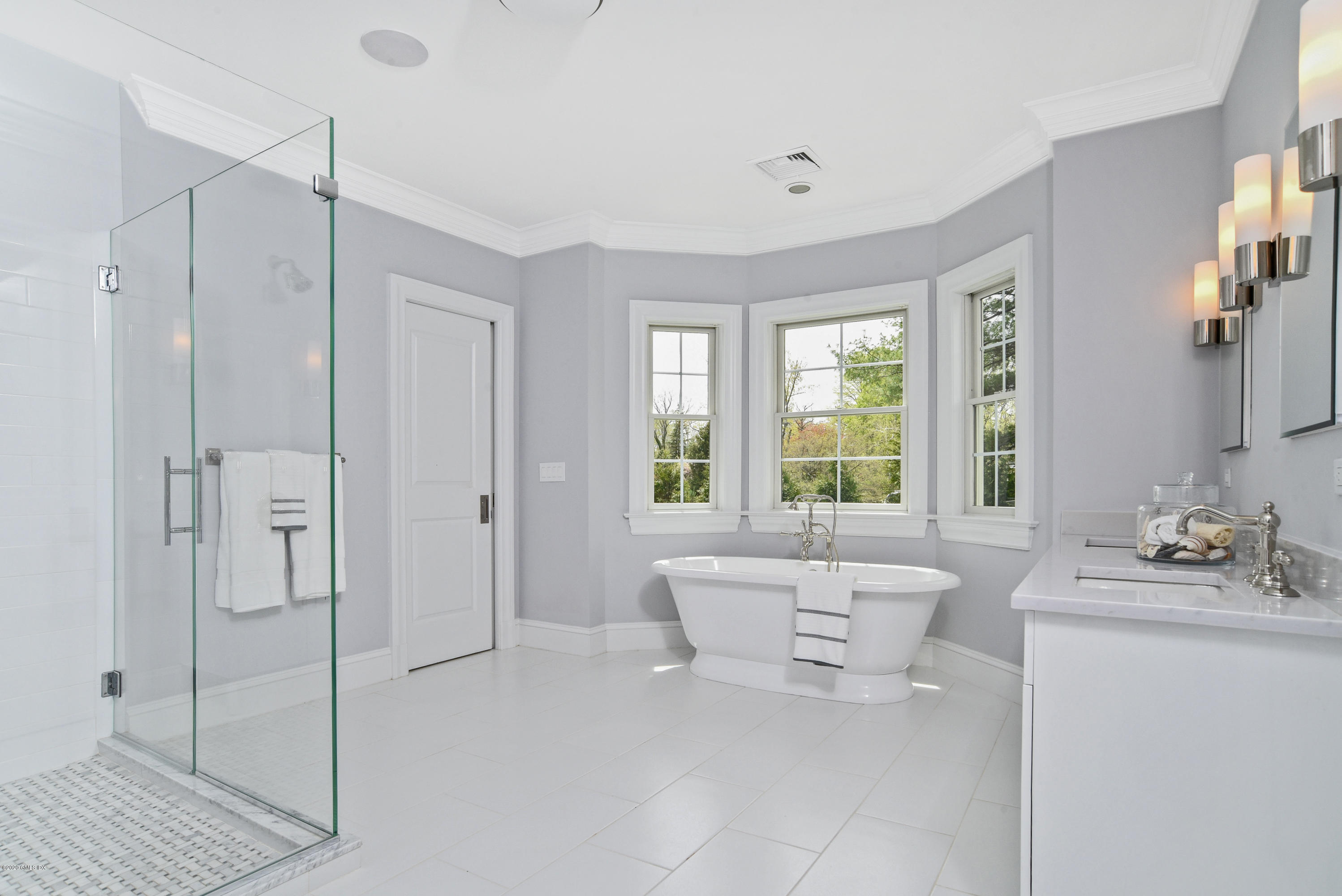 154 Byram Shore Road Greenwich, CT 06830 - Photo 15 of 37 a spacious bathroom with a double vanity sink a large mirror and a bathtub