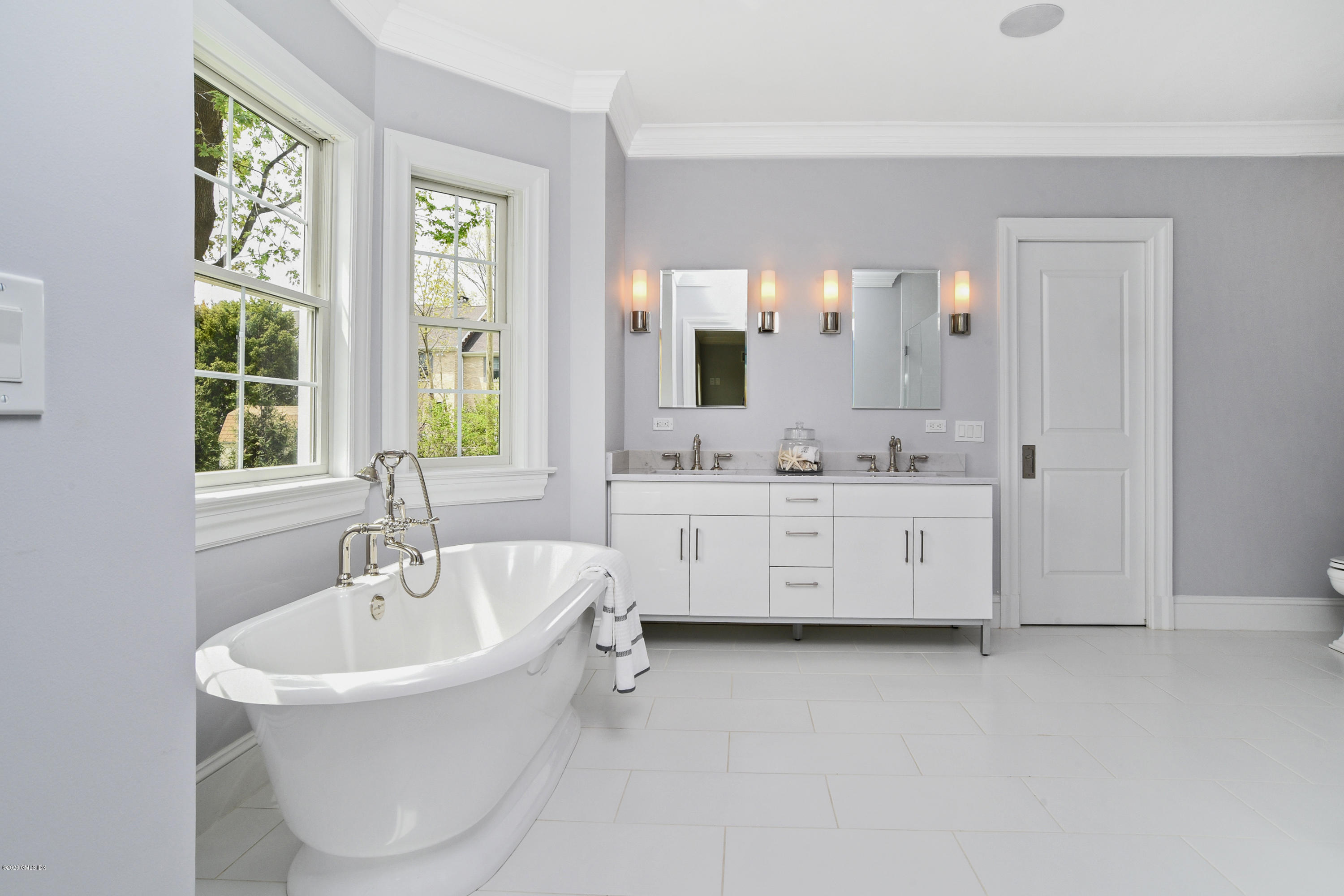 154 Byram Shore Road Greenwich, CT 06830 - Photo 16 of 37 a bathroom with a double vanity sink a mirror and a bathtub