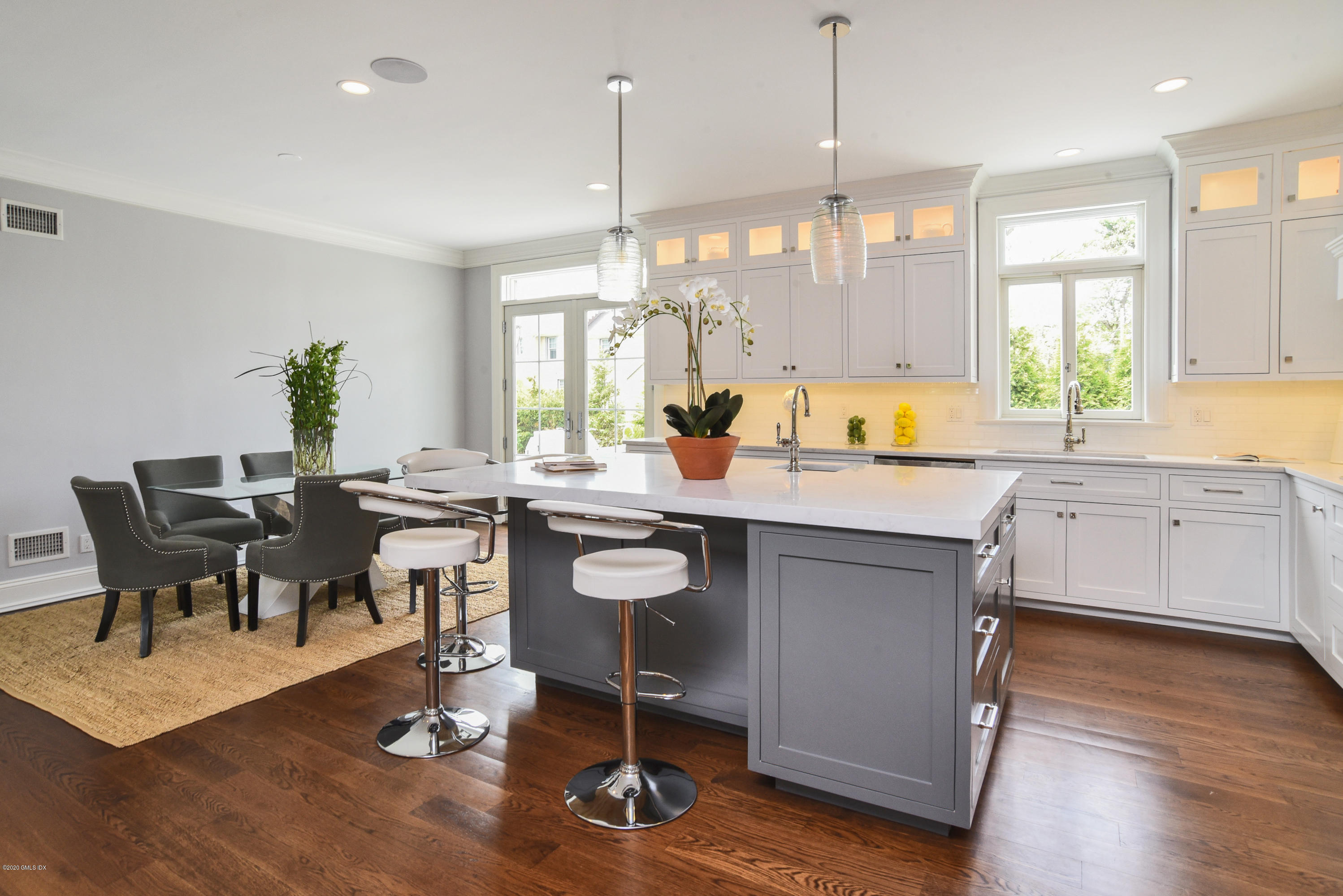 154 Byram Shore Road Greenwich, CT 06830 - Photo 10 of 37 a open kitchen with a dining table chairs and white cabinets with wooden floor