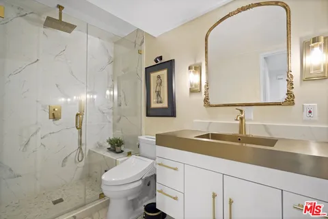 a bathroom with a sink a toilet and shower