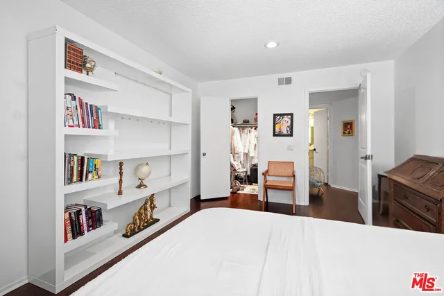a bedroom with furniture and a book shelf