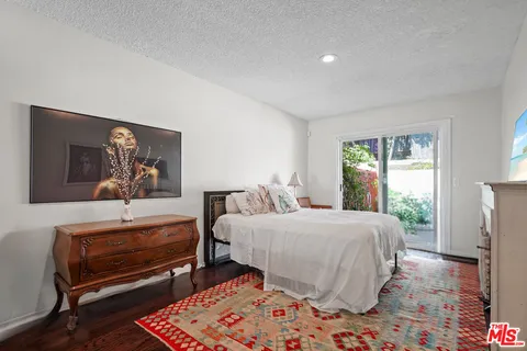a bedroom with a bed and a dresser next to a window